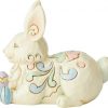 Laying down, this sweet bunny is as relaxed as he is happy. Surrounded by painted Easter eggs, this little rabbit is ready for showers and flowers.